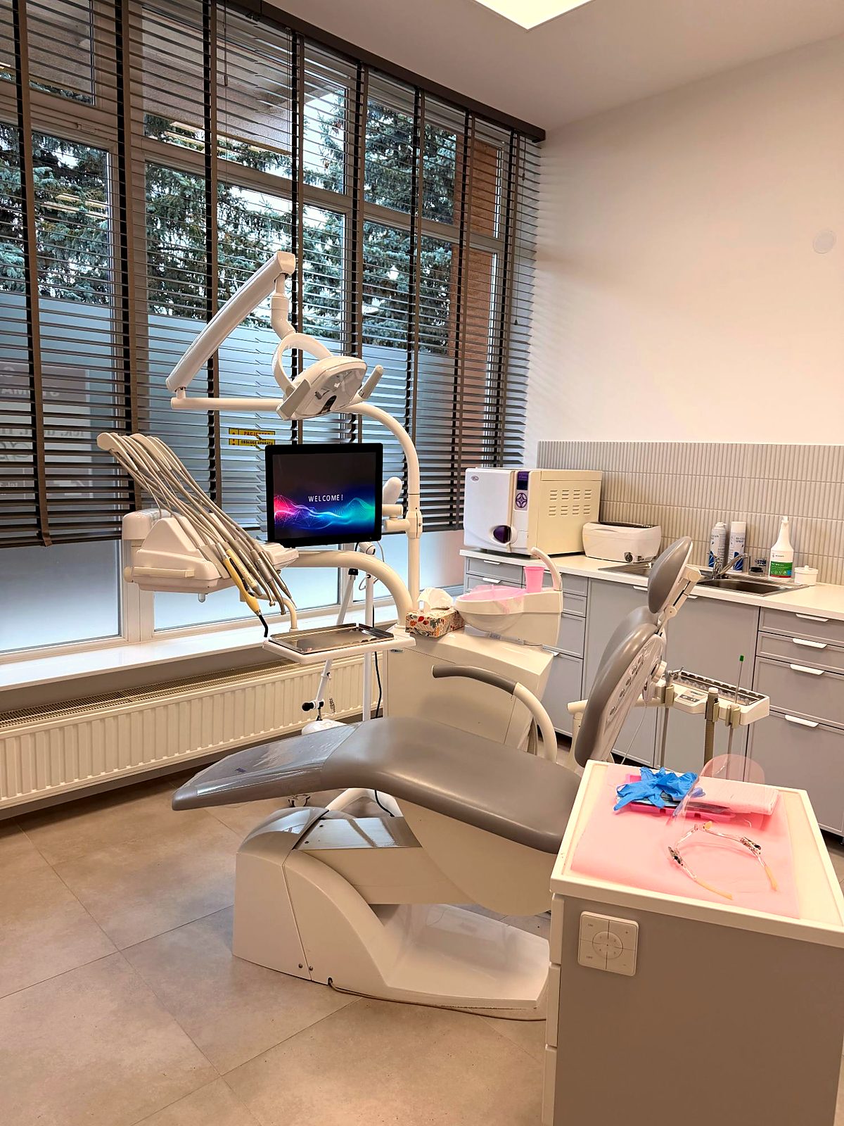 Gabinet zabiegowy – nowoczesny unit stomatologiczny przy dużych oknach